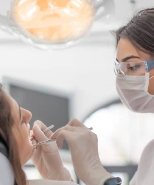 Dentist examining a patient's tooth with a cavity before recommending a dental filling to prevent further damage | Delaying a Dental Filling