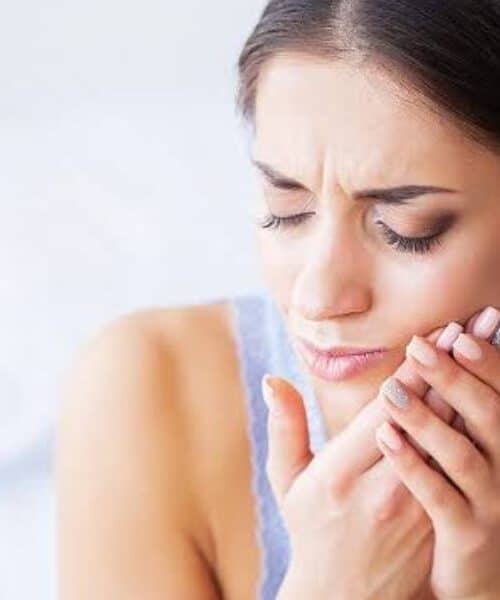 Patient holding a broken tooth while contacting an emergency dentist for prompt treatment after a weekend dental accident | Break a Tooth on the Weekend